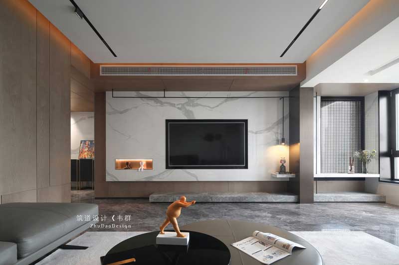設(shè)計師巧妙地運用色彩和燈光，把看似獨立的空間完全打開并融于整體。木色的護(hù)墻、簡潔的裝飾、大理石電視背景以及擺放家具中夾雜的跳色的點綴，將原本素雅大氣的空間變得有了些許生活氣息。