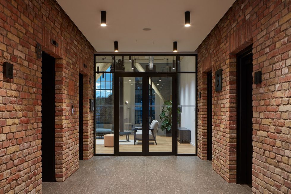 深色工業(yè)風(fēng)辦公室裝修設(shè)計暖色調(diào)電梯廳